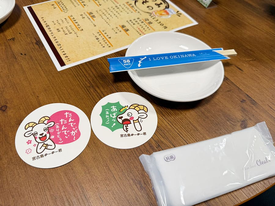 宮古島 平良 居酒屋めーめー ヤギ料理 店内 雰囲気 テーブル席 皿 コースター ウェットティッシュ おしぼり