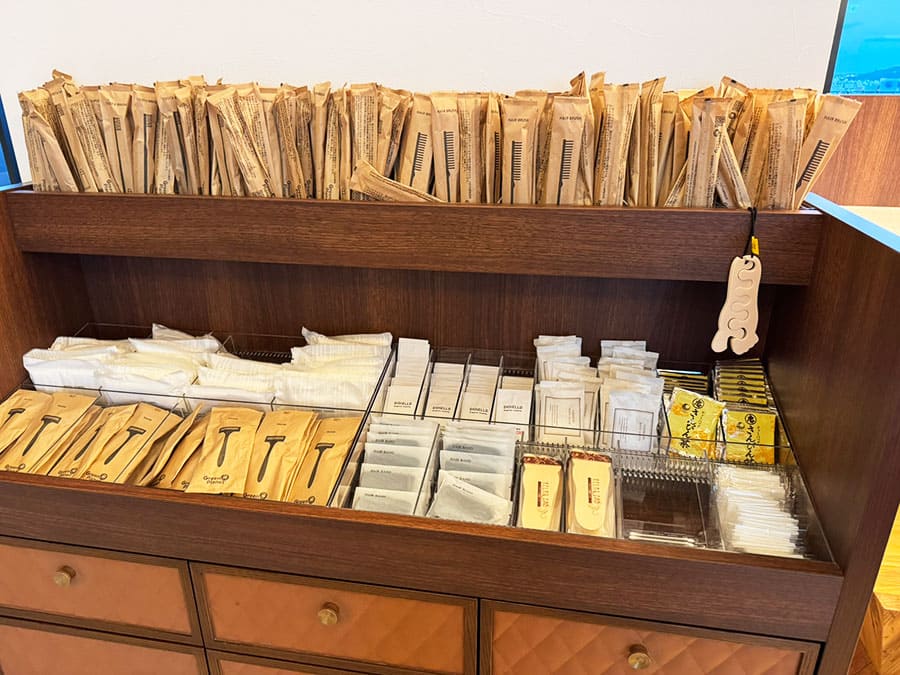 那覇市 ラ・ジェント・ホテル沖縄那覇 ロビー 受付 レセプション フロント アメニティバー カミソリ ブラシ ボディタオル ヘアバンド コットン 綿棒 バスソルト 化粧水 乳液 クレンジングオイル 洗顔料 ティーパック さんぴん茶 リラックス足指パッド